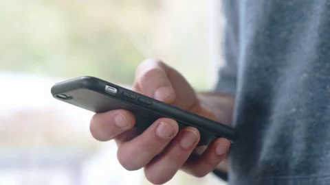 Slow-mo shot of hispanic man scrolling through social media page on smartphone Stock Footage 84479956