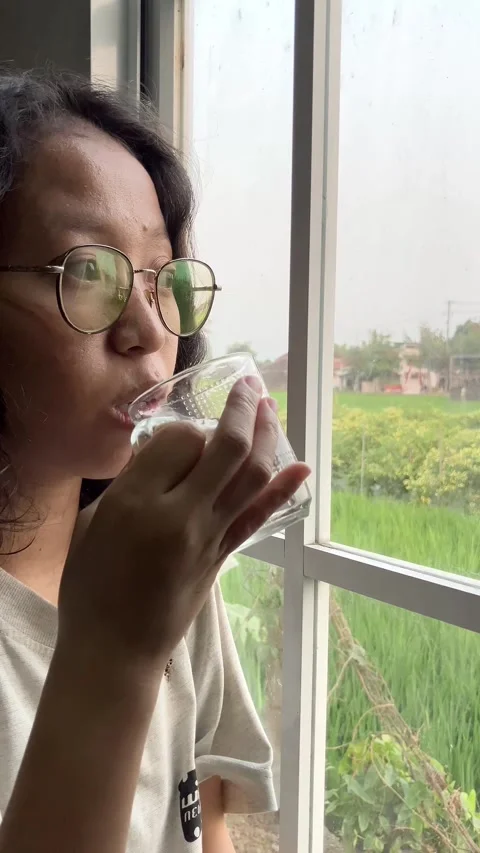 Slow mo sick woman taking medicine with water by hospital window. Stock Footage 342407978