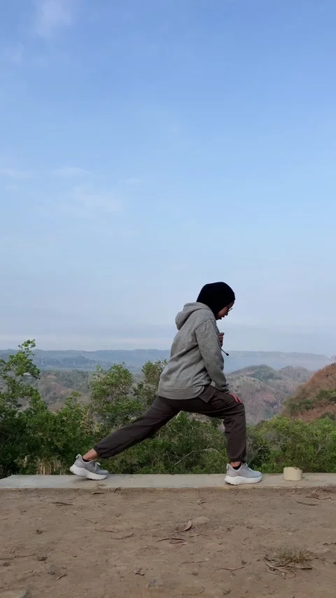 Slow mo side view of hijab woman doing lunge stretch exercise outdoors. Stock Footage 342369368