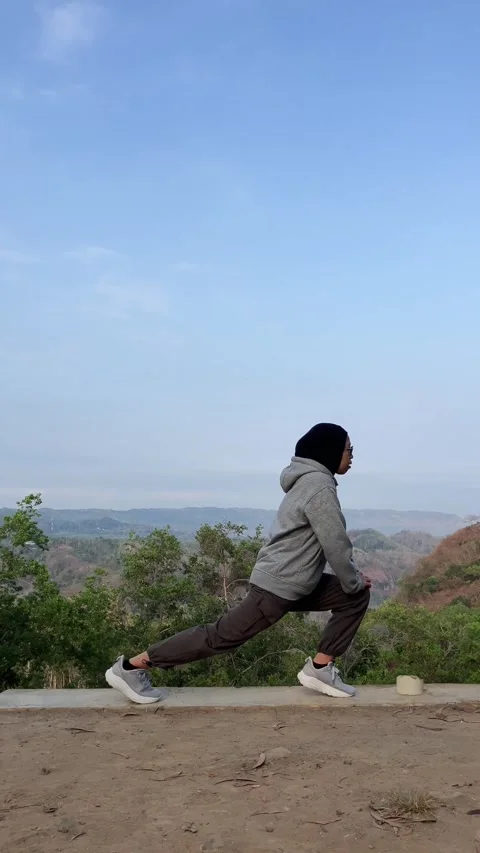 Slow mo side view of hijab woman doing lunge stretch exercise outdoors. Stock Footage 342369395