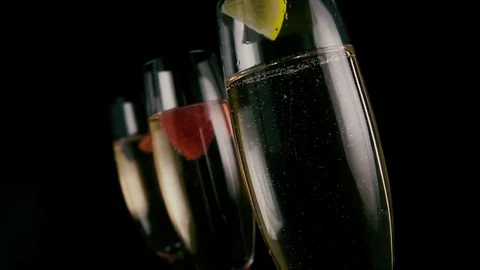 Slow mo. A slice of lemon drops into champagne Stock Footage 75951873