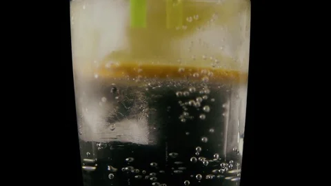 Slow mo. A straw in a glass of lemon water Stock Footage 76155214