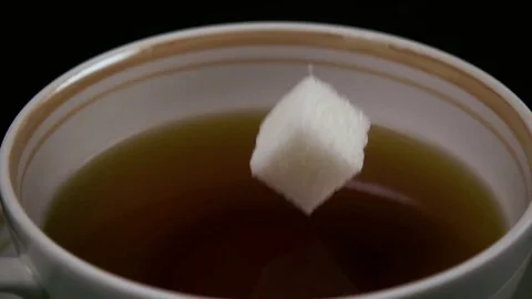 Slow mo. In the tea throws sugar and milk flows Stock-Footage 75811311