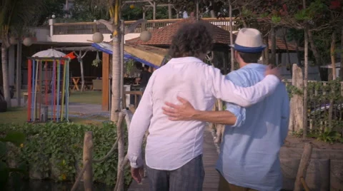 Slow mo of two middle aged male friends putting their arms around each other Video stock 55457652