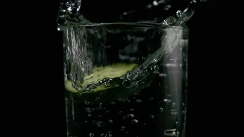 Slow mo. Two slices of cucumber fall into a glass Stock Footage 75716397