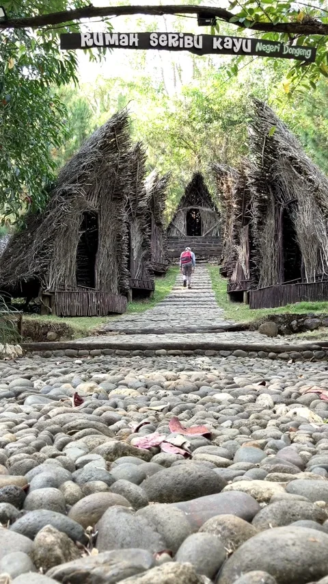 Slow mo vertical low angle of cobblestone path leading to rustic traditional hut Видео 341917057
