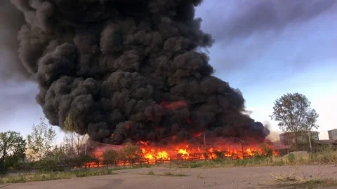 Slow-Mo of Warehouse engulfed in raging fire with huge column of smoke Stock Footage 78494034