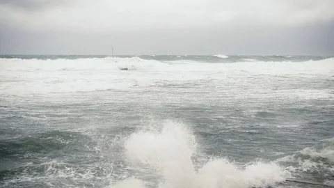 Slow mo wave breaks down on concrete slabs on the shore Stock Footage 81961828