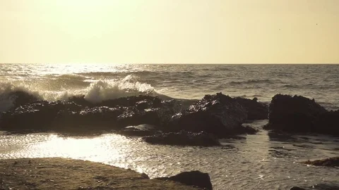 Slow mo waves break on boulders Stock Footage 82423421
