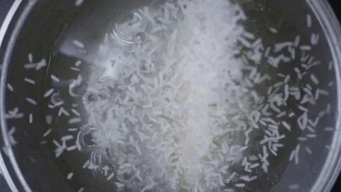 Slow mo white long grain rice falls into the water Stock Footage 73073348