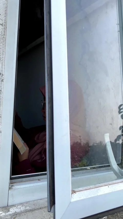Slow mo window reflection of muslim woman reading book inside. Stock Footage 343098305