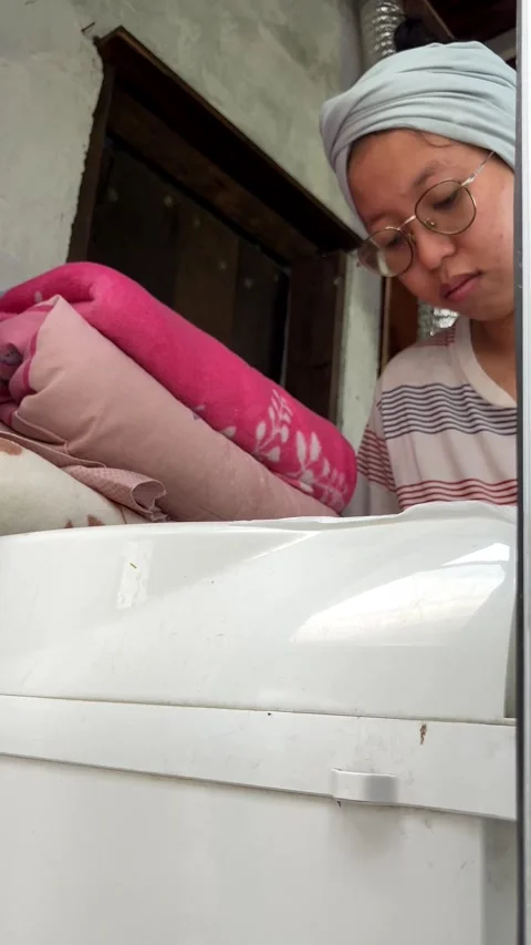 Slow mo woman doing laundry putting red clothes into washing machine. Vídeo Stock 343099290
