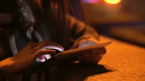 Slow mo of woman s hands using a tablet. Marriage rings on the finger, cars pass Stock Footage