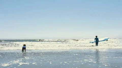 Slow-Mo | Young Boy Playing on the Beach By A Surfer Stock Footage 137763205