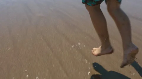 Slow-Mo | Young Boy Running Into the Water on the Beach Stock Footage 137763133