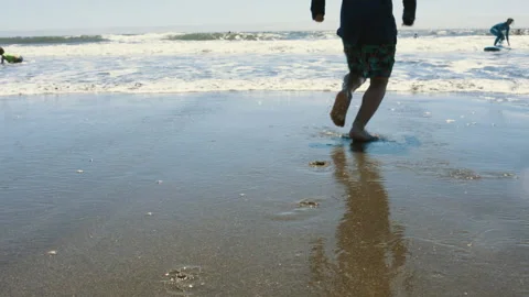 Slow-Mo | Young Boy Runs Into the Ocean From the Beach Stock Footage 137763204