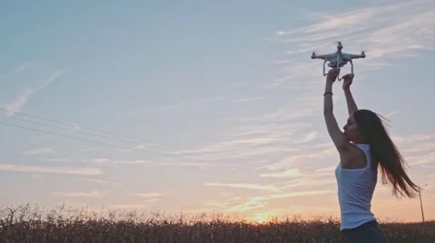 SLOW MOTION 240 fps: Drone is taking off from woman's hands in the sunset field. Vidéo 54077982