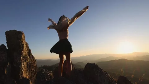 Slow motion 4 K, Silhouette of a woman raising her hands on the top of the .. Stock-Footage 336935073