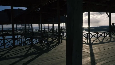 Slow motion 4K Beach Pier Parallax Tracking Shot with silhouette of young man Stock Footage 92224225