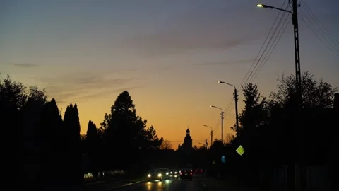 Slow motion 4K drive through small town at dusk with glowing streetlights Stock Footage 303927079