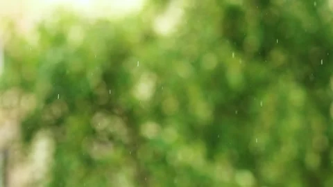 Slow motion 4k shot of sparkling sun shower raindrops falling against an abst 스톡 동영상 334862098