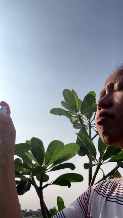 Slow Motion 4K Side View of Young Woman Spraying Face Mist Hot Summer Stockbeeldmateriaal 337641997