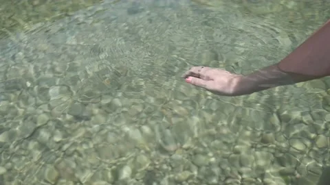 Slow motion 4K video of female hand moving in the turquoise water of a natura Video stock 197319076