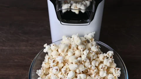 Slow motion 4K video of popcorn machine producing popcorn out into bowl Stock Footage 167922676
