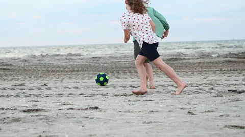 Slow motion 4K video of two happy teenagers playing with ball on beach Stock Footage 155867622
