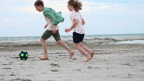 Slow motion 4K video of two happy teenagers playing with ball on beach Stock Footage 155884219