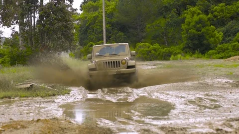 Slow motion 4x4 offroads in mud puddle toward camera Stock Footage
