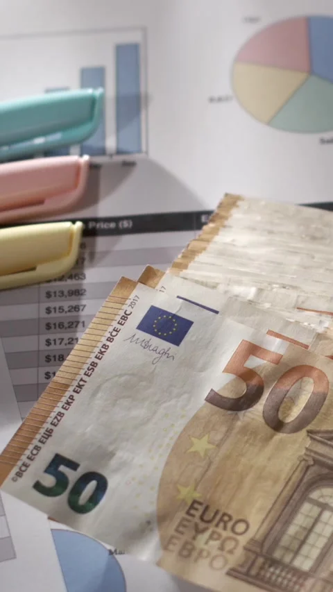 Slow motion of a 50 euro note moving above a financial report Stock Footage 337229828