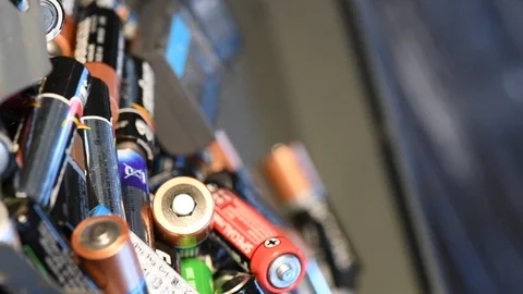 Slow motion aa and aaa batterys being recycled Stock Footage 100820336