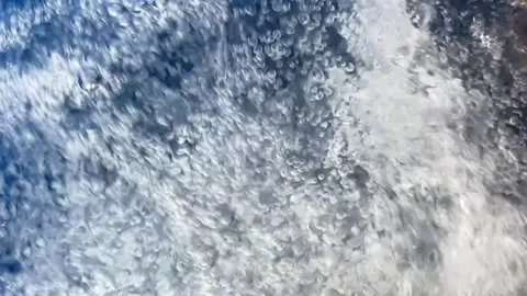 Slow motion abstract texture of blue bubbling and swirling water inside a w.. 스톡 동영상 342737573