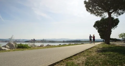 Slow Motion Of Active Couple Jogging By The Seaside Stock Footage 123712336