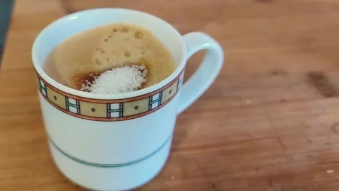 Slow motion of adding sugar into hot coffee cup, close-up Video stock 329396387