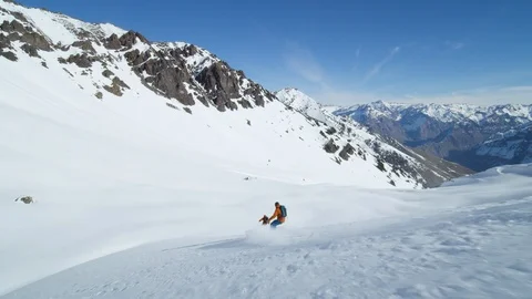 Slow motion of advanced skier and snowboarder riding down freeride terrain Stock Footage 121597867