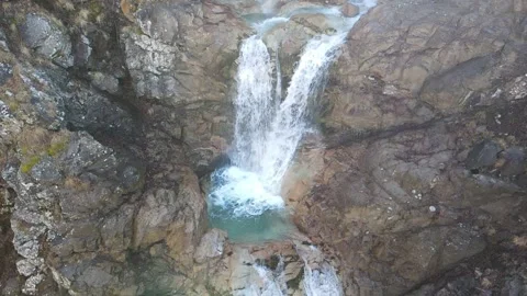 Slow motion aerial drone approach to a scenic mountain waterfall Stock Footage 337538257