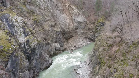 Slow motion aerial drone view of a powerful mountain river in early spring Stock Footage 337542573