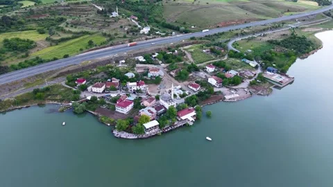 Slow Motion Aerial Orbit Around Lakeside Town and Road Vidéo 345166950