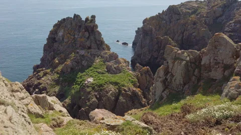 Slow motion aerial panorama of cliffs, sea-stacks. The 'Pea Stacks', Guernsey Stock Footage 252926062