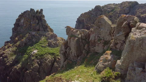 Slow motion aerial panorama of cliffs, sea-stacks. The 'Pea Stacks', Guernsey Stock Footage 252926104
