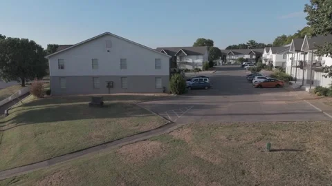 Slow motion aerial push down residential street past apartment buildings Stock Footage 346732202