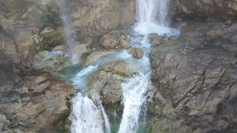 Slow motion aerial view of a mountain waterfall cascade Video stock 337538189