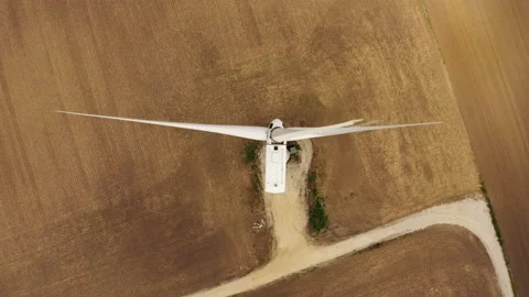 Slow motion: Aerial view of a wind turbine in a golden field Stock Footage 143437459