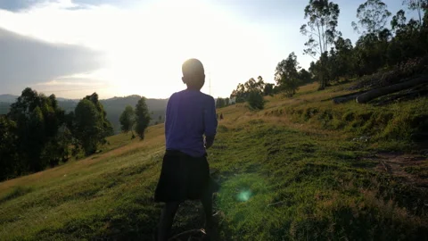 Slow Motion of African Child walking, Sun Reflection, Sunset. Stock Footage 194536799