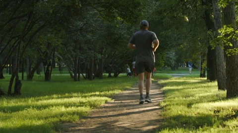 SLOW MOTION: Aged man runs on a footpath Видео 67824775