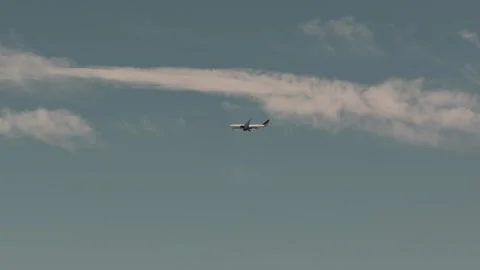 Slow Motion Airliner Crossing Wispy Clouds in Open Sky Stock Footage 336757228