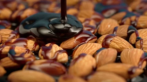 Slow motion almonds are poured with chocolate on a black background Stock Footage 148221977