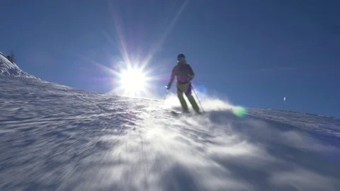 Slow motion - Alpine skier following the camera on ski slope on a sunny day Stock Footage